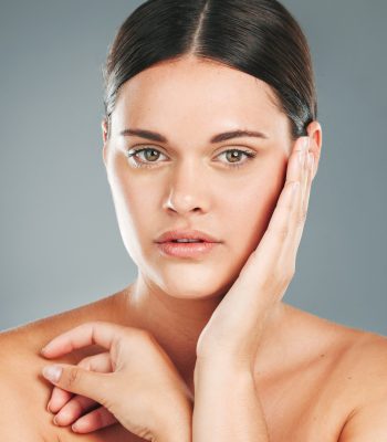 Beauty, portrait and woman hands touching face in studio for wellness, luxury facial and cosmetics. Young female model, aesthetic skincare and dermatology from healthy shine, glow and salon results.