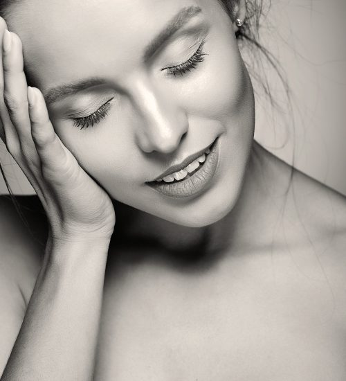 portrait of beautiful woman model with fresh daily makeup and red lips and healthy skin touching her head