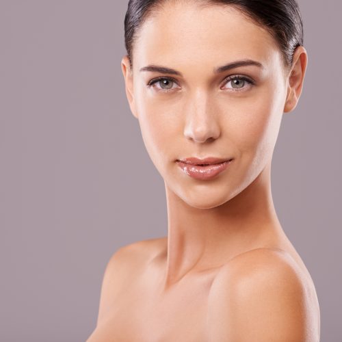 Portrait, woman and glow for makeup, beauty and skincare on mockup studio on grey background. Confident, female person and cosmectics for dermatology, flawless skin and healthy natural aesthetic.