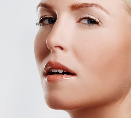 Woman, glow and skincare in studio portrait, foundation and makeup treatment on white background. Female person, dermatology and confidence for shine, smooth skin and facial wellness for cosmetics.